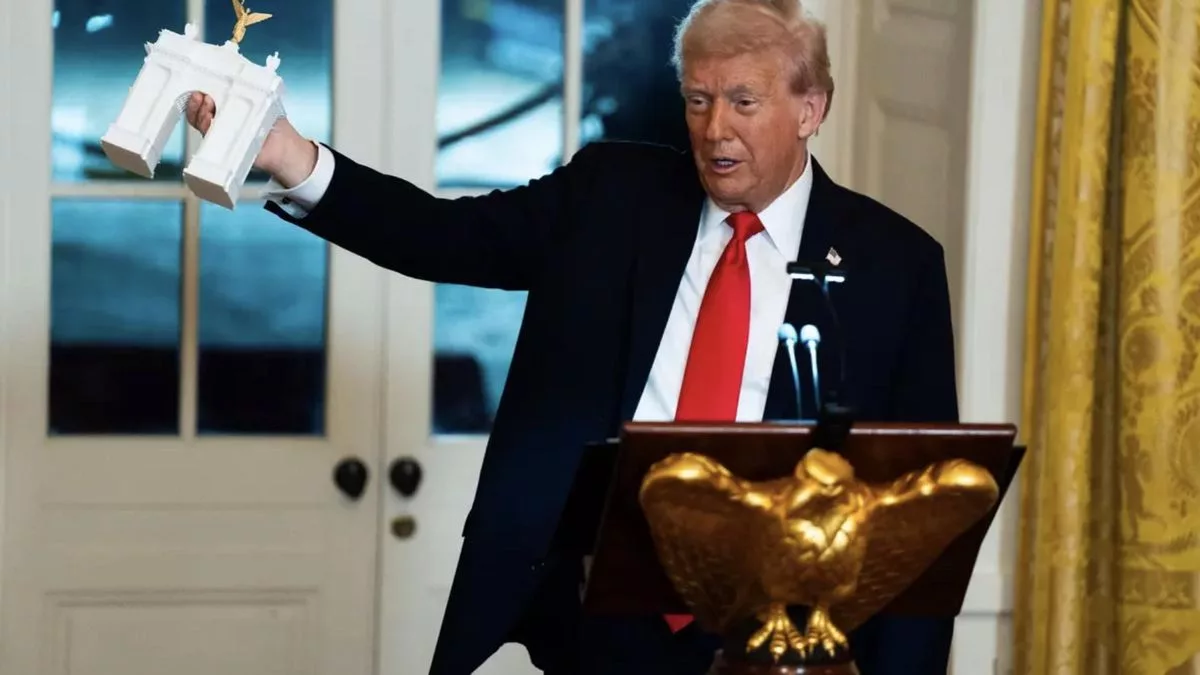 Donald Trump sostiene una maqueta del Arco, en una cena benéfica en la Casa Blanca el 15 de octubre de 2025.