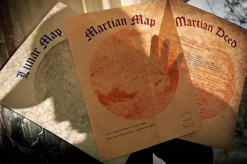 Hope empezó a vender propiedades. En la imagen, los mapas de las parcelas disponibles en la Luna y en Marte, junto a la escritura de una propiedad en Marte.