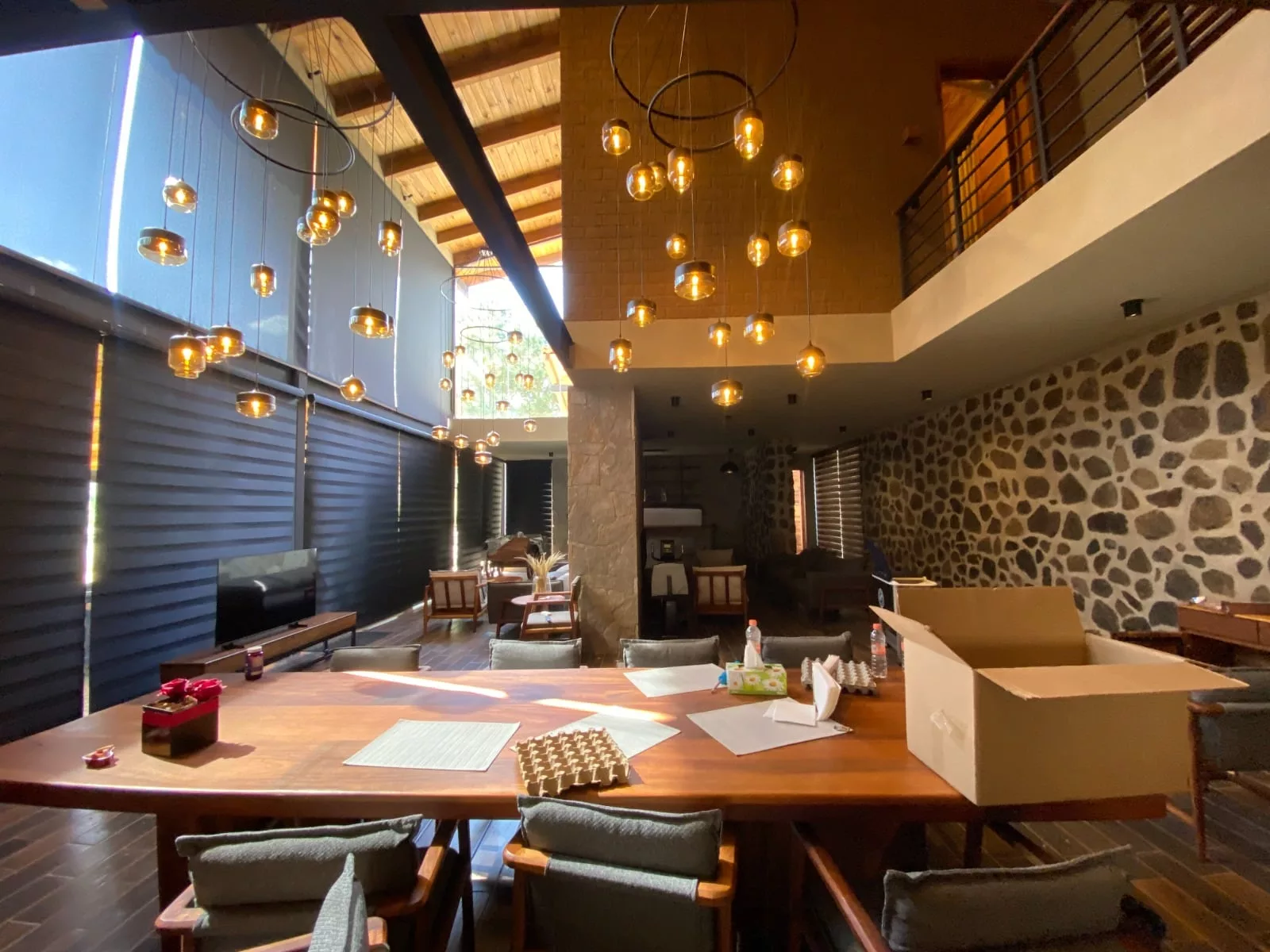 El comedor de la vivienda, vestido con dos grandes arañas, detalles en madera y piedra