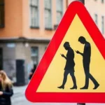 La DGT empieza a multar a los peatones que cruzan la calle distraídos con el móvil