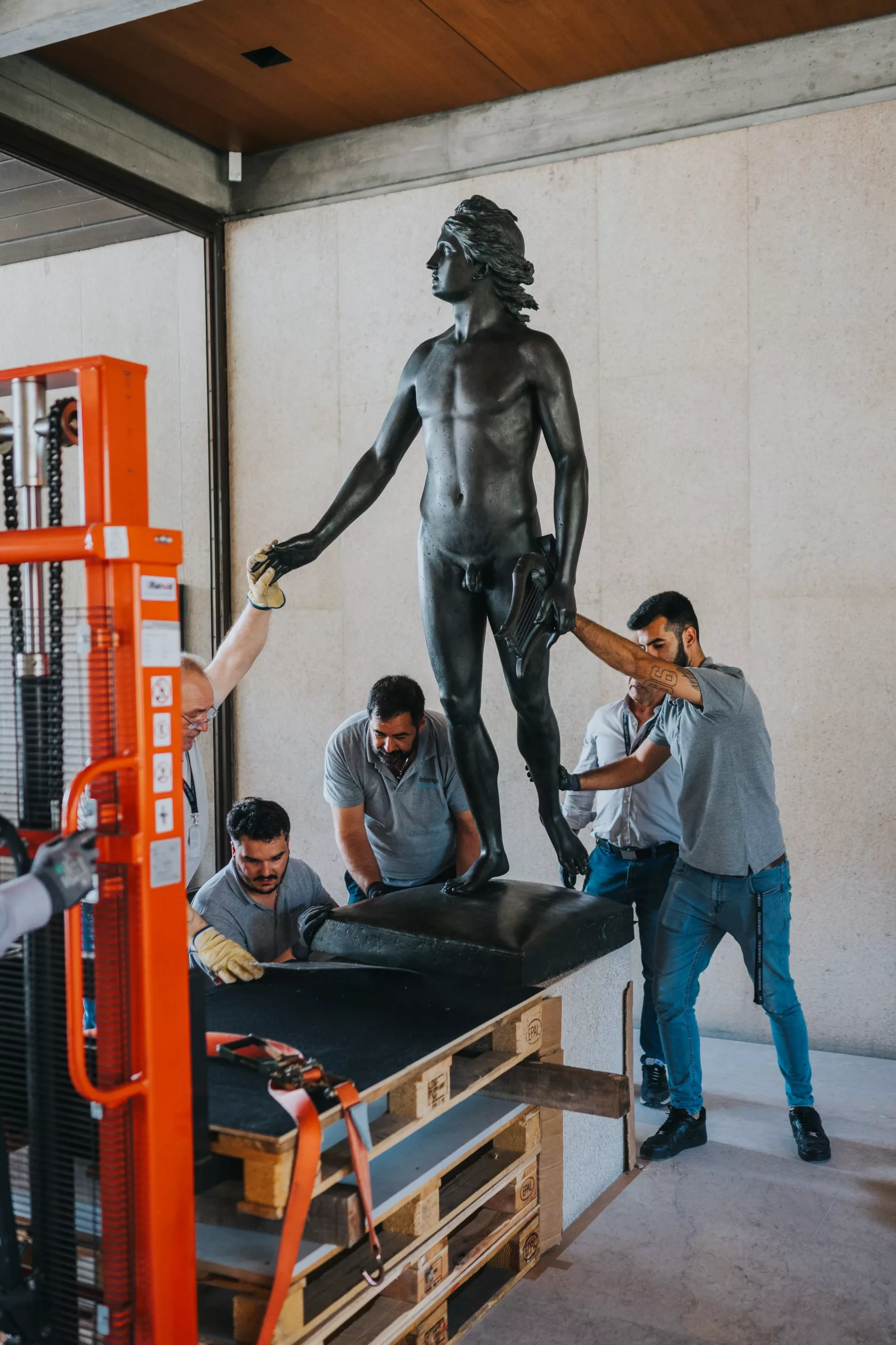 Varios trabajadores colocan una estatua tras la renovación de las salas del museo.