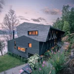 Hecha en madera, una casa de 11 metros de altura encontró su lugar entre la montaña y el lago