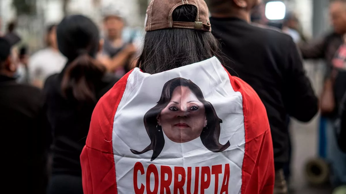 Una persona sostiene una bandera de Perú con la imagen de la presidenta, Dina Boluarte, durante una manifestación este jueves, en Lima (Perú).